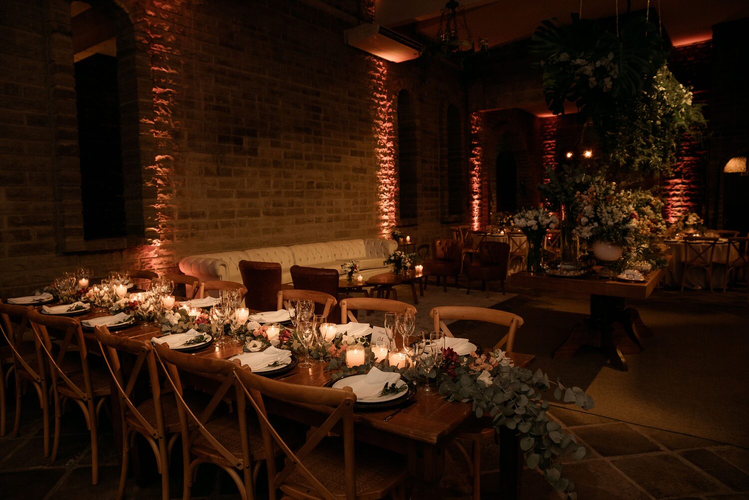 A candlelit wedding reception table set with flowers